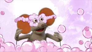 Foto van Ienieminie met erbij getekend roze wolkjes en heeft een aparte roze bril op.