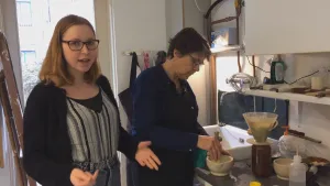 Foto van twee vrouwen die staan in een atelier, bereiden emailleren voor.