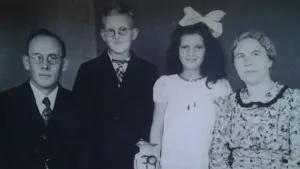 Oude foto, zwart/wit, van een gezin, netjes gekleed en geposeerd, ten tijde van de Tweede Wereldoorlog.