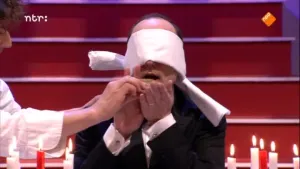 Foto van een man met blinddoek om, je ziet zijn hoofd, in de studio van Snugger.