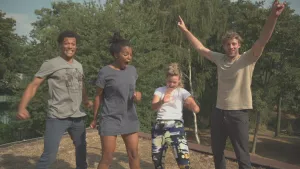 Foto van aantal personen die buiten in de natuur staand oefeningen doen.