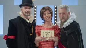 Foto van presentator, bij haar staan twee mannen verkleed als ten tijde van de 80-jarige Oorlog.