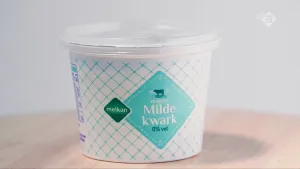 Foto van een ronde pot met plastic deksel met kwark erin.