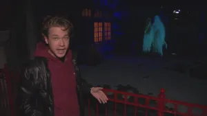 Foto van presentator die staat in donkere ruimte, van het sprookje Meisje met de zwavelstokjes, met hologram, Efteling.