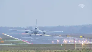 Foto van een vliegtuig van achteren gezien dat landt op een landingsbaan.