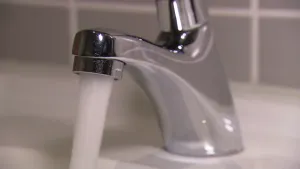 Foto van een kraan die aan staat, er komt water uit, van dichtbij genomen.