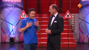 Foto van de studio van Snugger, presentator in gesprek met een andere man, bij ze staan twee verkeersborden.