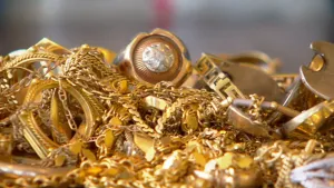 Foto van aantal gouden objecten op een hoop zoals ringen, kettingen.