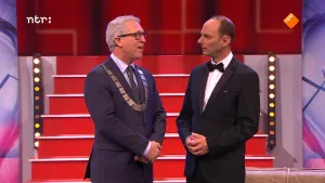 Foto van de presentator van Snugger die in de studio staat bij een andere man.