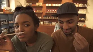 Foto van een man en vrouw die beiden aan een geurstrookje ruiken in een parfumwinkel.
