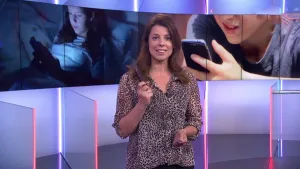 Foto van presentator die staat in de studio, achter haar grote foto van twee kinderen die kijken op een smartphone.