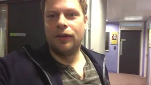 Foto van een jongen die staat in de gang van een modern gebouw, de werkplek van Stephen Hawking.