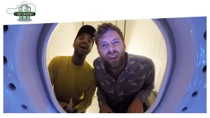 Foto genomen door een ronde vorm met een gat, erachter twee mannen die door dat gat heen kijken.