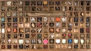 foto van een ouderwetse houten apothekerskast met vele vakjes met daarin allerlei poeders etc.