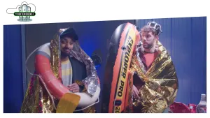 Foto van twee mannen apart verkleed, de ene met een reddingsboei om, de andere houdt een reddingsboot vast.