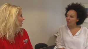 Foto van presentator in gesprek met een donkere vrouw, arts.