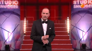 Foto van de presentator van Snugger die staat in de studio.