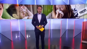 Foto van presentator die staat in de studio met achter hem foto van man en vrouw, je ziet hun gezicht, die de griep hebben.