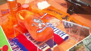 Foto van oranje objecten voor het Oranje Voetbalteam zoals sjaals en een klomp.