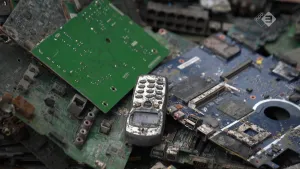 Foto van oud materiaal van computers zoals printplaten en een oude afgedankte smartphone.