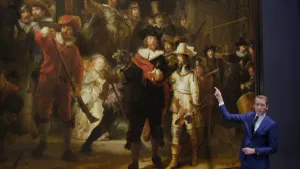 Foto van de Nachtwacht, rechts staat ervoor presentator die ernaar wijst.