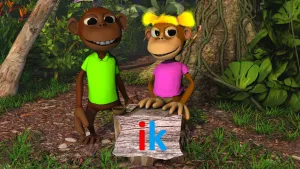 Foto van twee aapachtige figuren (poppen) die in de jungle staan met voor hen houten bordje met rode letter I, blauwe letter K.