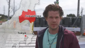 Foto van presentator met op de achtergrond getekende kaart van Japan waarop ook Fukushima staat aangegeven.
