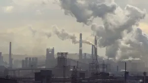 Foto van zware industrie met fabrieksgebouwen, pijpen met veel roook.