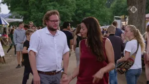 Foto van man en vrouw die lopen over het terrein van een festival, evenement, vrij druk, in park.