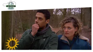 Foto van man en vrouw die staan in het bos, tegen een boom staat een ladder.