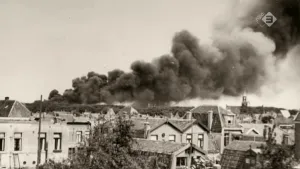 Oude foto, zwart/wit, van stad met grote rookwolken van het bombardement van Den Helder.