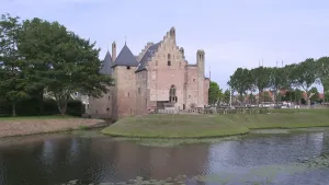 Foto van een kasteel dat staat langs het water, ringvaart, gracht.