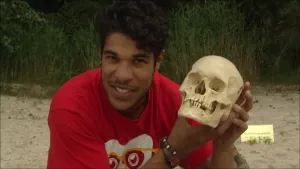 Foto van presentator die een schedel van een mens vasthoudt.