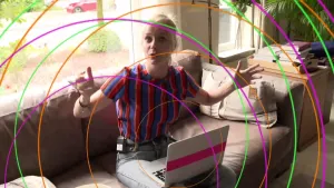 Foto van vrouw die met een laptop op schoot op de bank zit, over de foto heen zijn allerlei cirkels in verschillende kleuren getekend.
