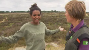 Foto van twee vrouwen die staan in groot heideveld van het Nationaal Park Drentsche Aa.