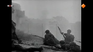 Oude foto, zwart/wit, met soldaten die op de grond liggen met geweren, veel rook, vaag iets van gebouw en bomen te zien.