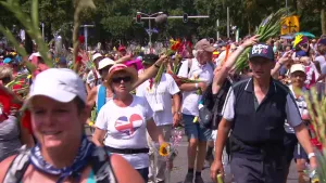 Foto van weg, de finish van de Vierdaagse, waarop vele wandelaars aan komen, aantal van hen met gladiolen in de handen.