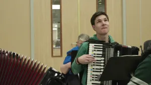 Foto van een man die op een accordeon speelt.