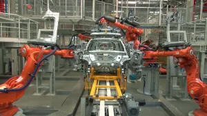 Foto van een productielijn met deel van auto in een autofabriek met robots, robotarmen.