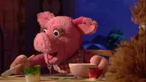 Foto van scène uit Sesamstraat waarop Purk (pop) aan tafel zit en schildert, verft.