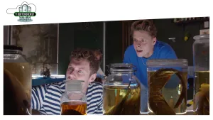 Foto van twee mannen die staan bij grote glazen flessen/potten met erin dieren op sterk water.