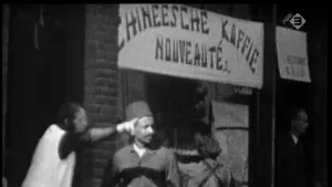 Oude foto, zwart/wit, ten tijde van de Crisis, waarop een Chinese winkel met paar Chinezen die erbij staan.