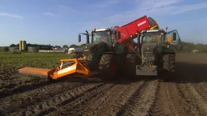 Foto van een grote landbouwmachine, landbouwwerktuig, op het land aan het werk.