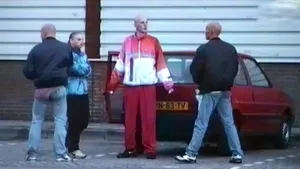 Foto van aantal jongens, Gabbers, rondom een auto op straat.