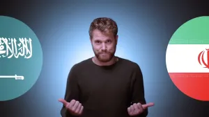 Foto van presentator met links en rechts van hem ronde afbeeldingen van de vlaggen van Saoedi-Arabië en Iran.