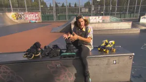 Foto van man die zit op onderdeel van een skatebaan, om hem heen staan meerdere rolschaatsen.