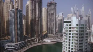 Foto van moderne stad met hoge flats, wolkenkrabbers, er loopt kanaal doorheen.