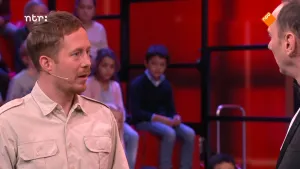 Foto van Studio Snugger waar je wat kinderen in het publiek ziet, de presentator en een andere man die bij hem staat.