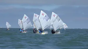 Foto van aantal kleine zeilboten, optimisten, die varen op de volle zee.