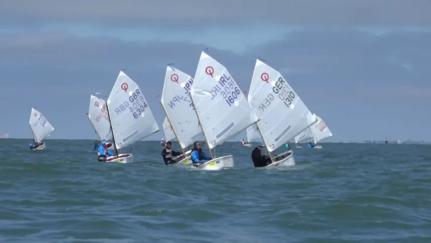 Foto van aantal kleine zeilboten, optimisten, die varen op de volle zee.